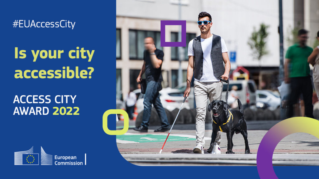 Η εικόνα δείχνει έναν τυφλό άντρα να περπατάει. Στο ένα χέρι κρατάει το λευκό μπαστούνι του και στο άλλο το σκύλο οδηγό. Δίπλα το κείμενο λέει: #EUAccessCity Is your city accessible? Access City Award 2022, ενώ υπάρχει και το σήμα της Κομισιόν